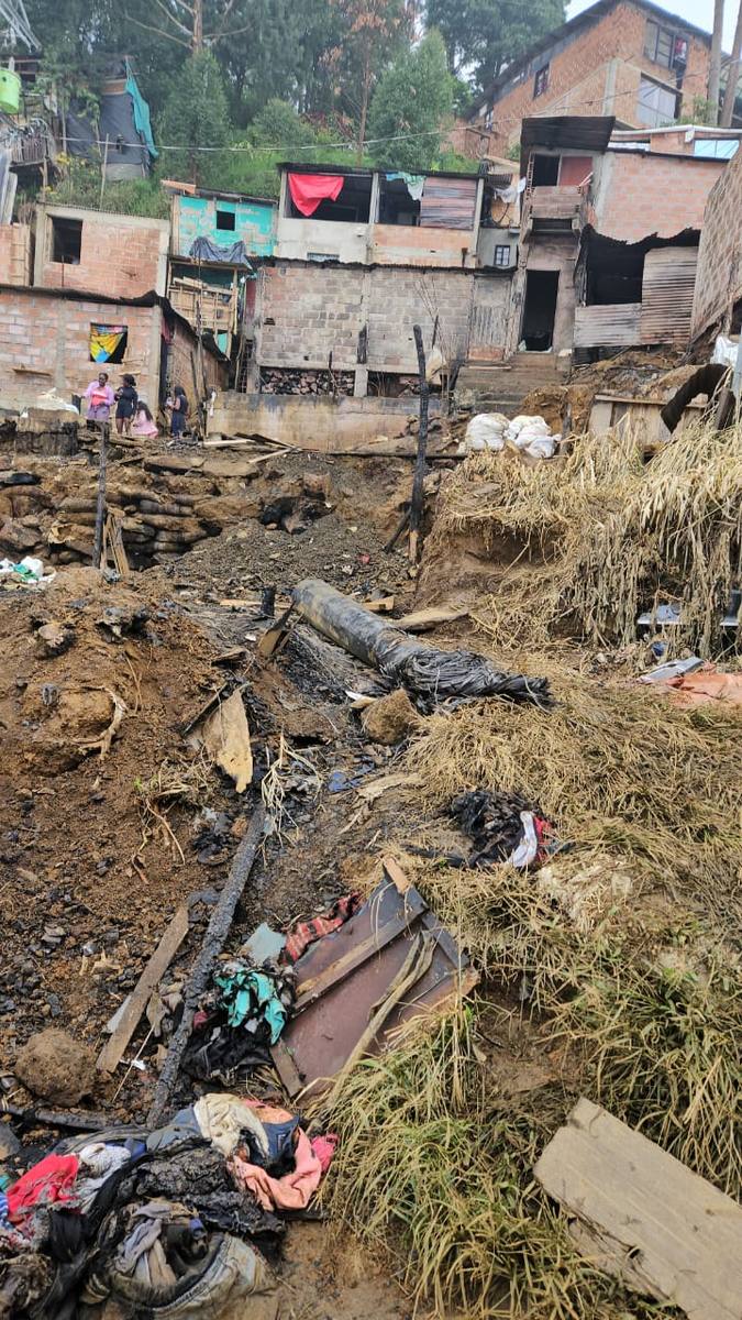 Residents standing above a burned hillside lot